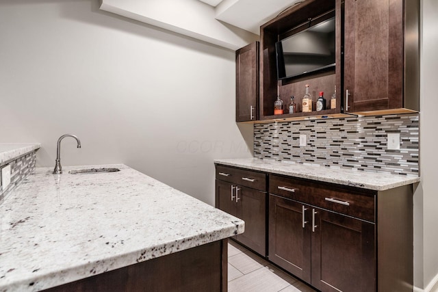 indoor dry bar with backsplash and light tile patterned floors