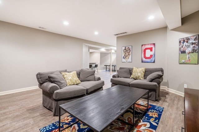 living area featuring baseboards, light wood-type flooring, and recessed lighting