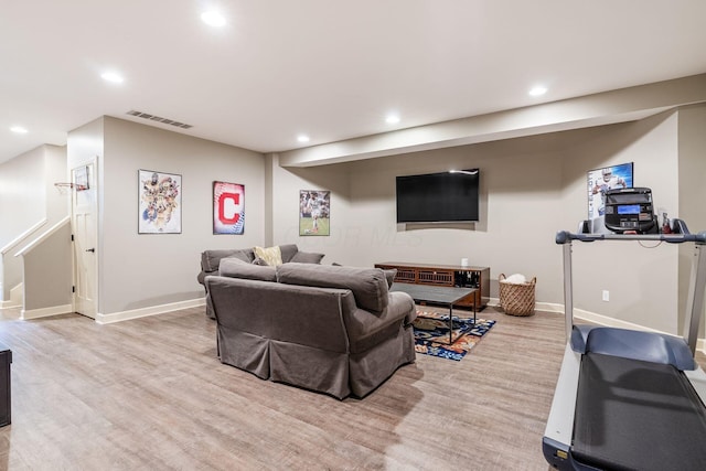 living room featuring recessed lighting, light wood finished floors, baseboards, and stairs