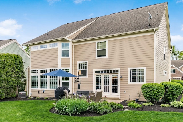 back of property with central AC unit, a yard, and a patio area