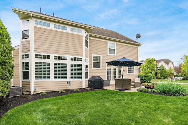rear view of property with a patio, a yard, and central air condition unit