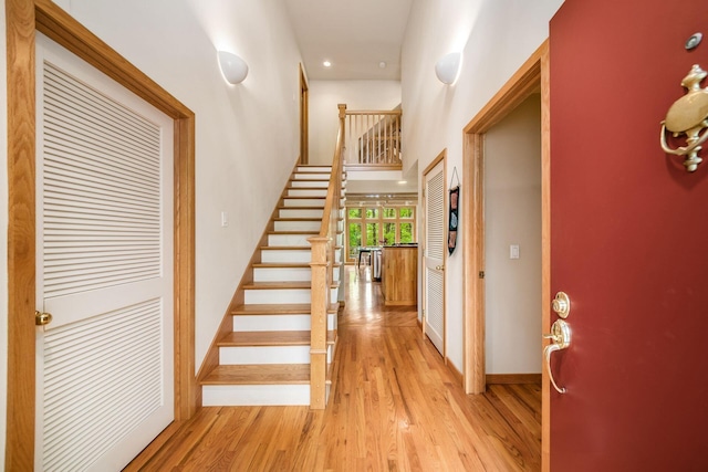foyer with light wood-style flooring, stairway, baseboards, and recessed lighting