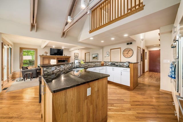 kitchen featuring light wood-style flooring, open floor plan, beamed ceiling, recessed lighting, and white cabinets