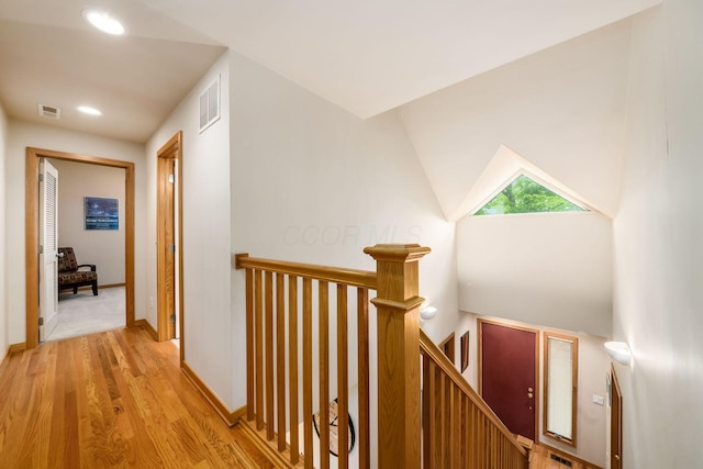 corridor featuring an upstairs landing, wood finished floors, recessed lighting, and baseboards