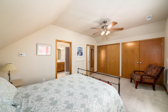 bedroom with light colored carpet, vaulted ceiling, multiple closets, ceiling fan, and ensuite bathroom