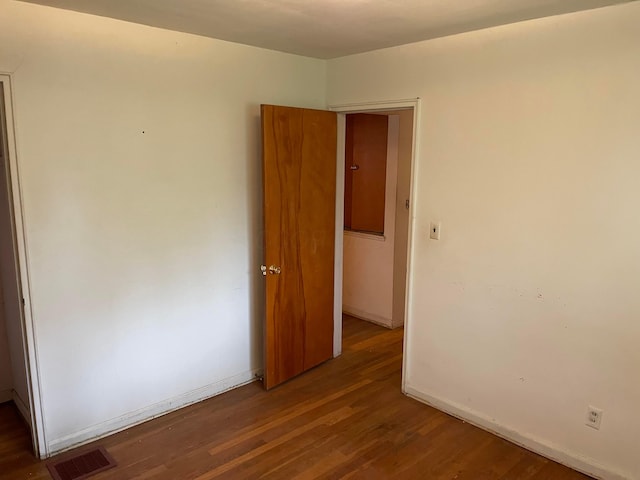 empty room with wood finished floors and baseboards