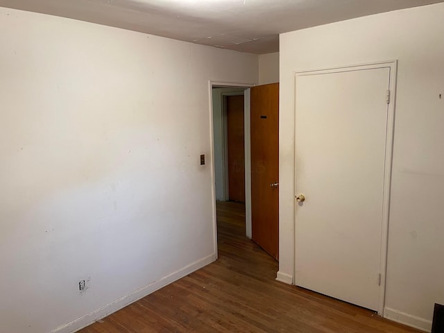 spare room with wood finished floors and baseboards