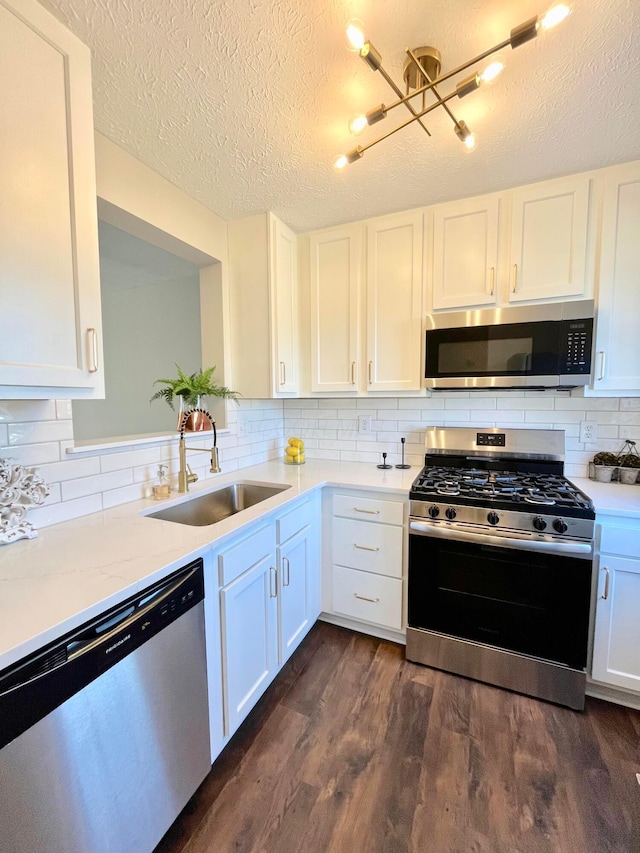 755 Parkbluff Way, Lewis Center, OH 43035 - kitchen with stainless steel appliances, a sink, dark wood-style floors, white cabinets, and a textured ceiling