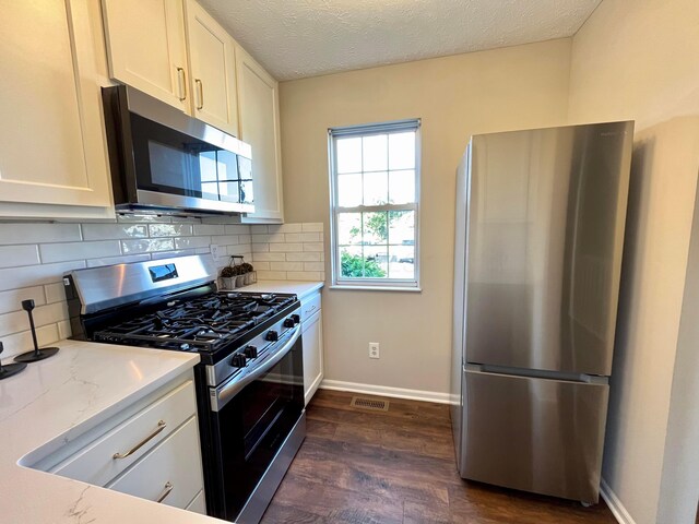 755 Parkbluff Way, Lewis Center, OH 43035 - kitchen with appliances with stainless steel finishes, dark wood finished floors, tasteful backsplash, white cabinets, and baseboards