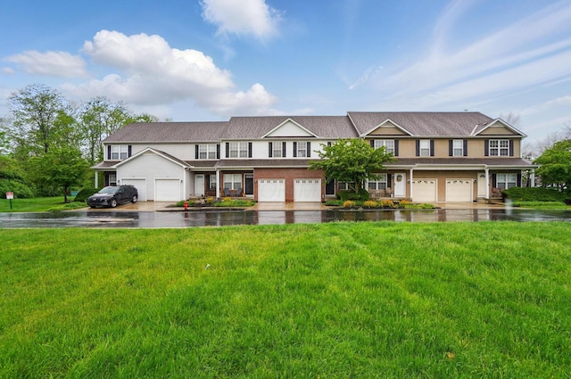 townhome / multi-family property featuring a front yard, a garage, and driveway