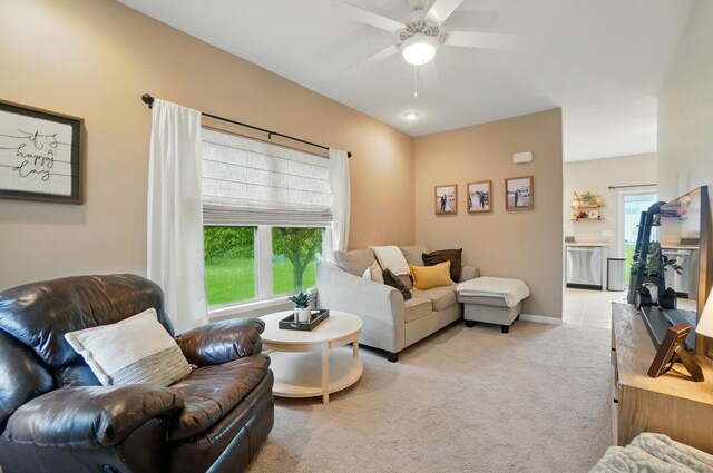 living room featuring light carpet, ceiling fan, and baseboards