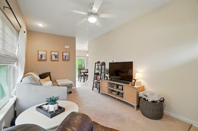 living area featuring carpet flooring, ceiling fan, and baseboards