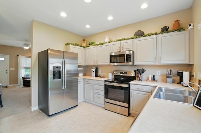 kitchen featuring stainless steel appliances, a sink, light countertops, recessed lighting, and a ceiling fan