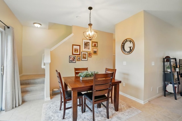 dining room featuring a chandelier, light tile patterned floors, and baseboards