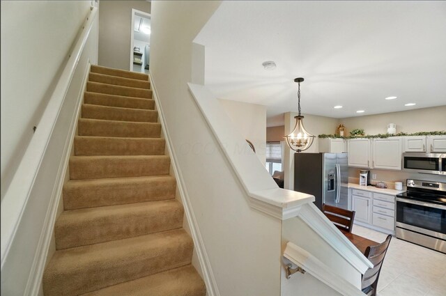 stairs with a chandelier, recessed lighting, and tile patterned flooring