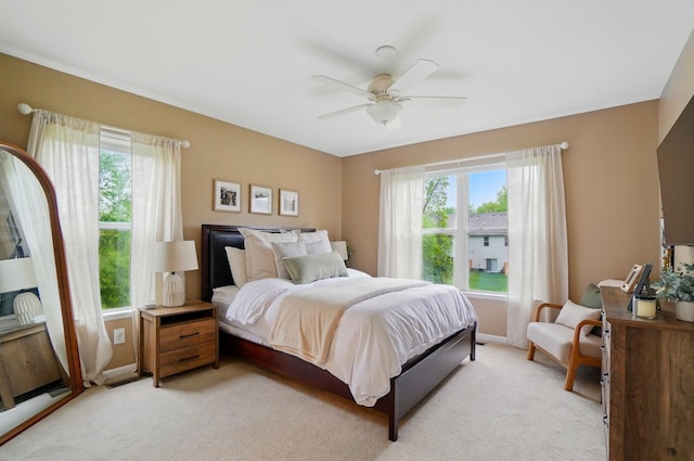 bedroom featuring multiple windows, light carpet, and baseboards