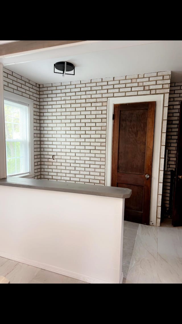 1065 Sunbury Rd, Columbus, OH 43219 - kitchen with light marble finish flooring and brick wall