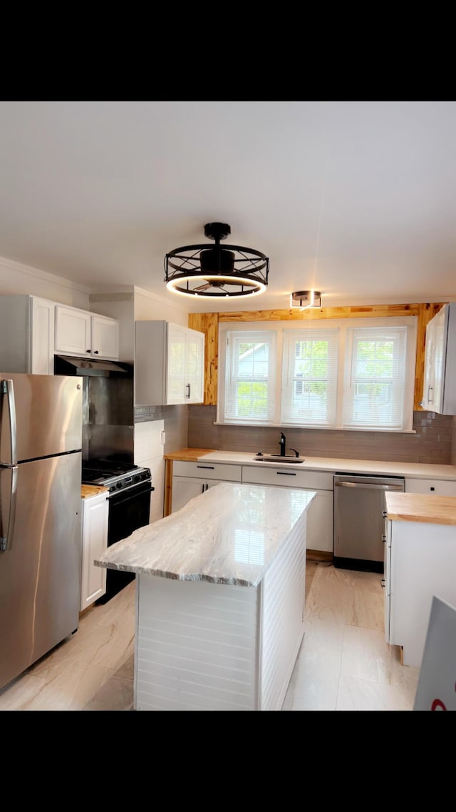 1065 Sunbury Rd, Columbus, OH 43219 - kitchen featuring appliances with stainless steel finishes, light marble finish floors, plenty of natural light, and white cabinetry
