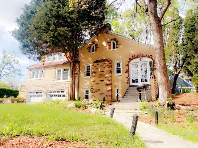 1065 Sunbury Rd, Columbus, OH 43219 - mediterranean / spanish home featuring a garage, french doors, and stucco siding