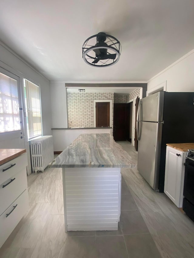 1065 Sunbury Rd, Columbus, OH 43219 - kitchen featuring radiator, white cabinetry, range, a kitchen island, and a ceiling fan
