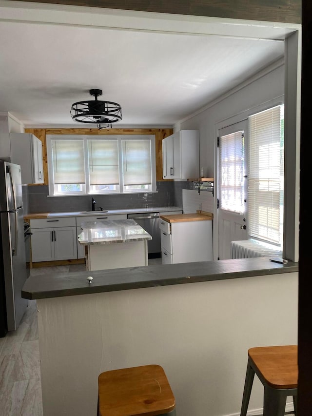 1065 Sunbury Rd, Columbus, OH 43219 - kitchen featuring appliances with stainless steel finishes, a center island, a kitchen bar, and decorative backsplash