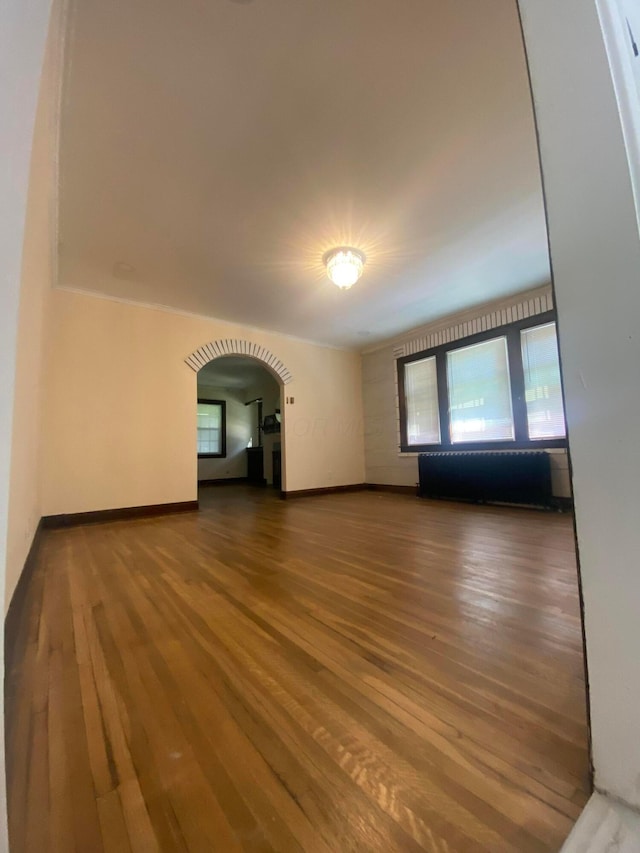 1065 Sunbury Rd, Columbus, OH 43219 - unfurnished living room featuring arched walkways and wood finished floors