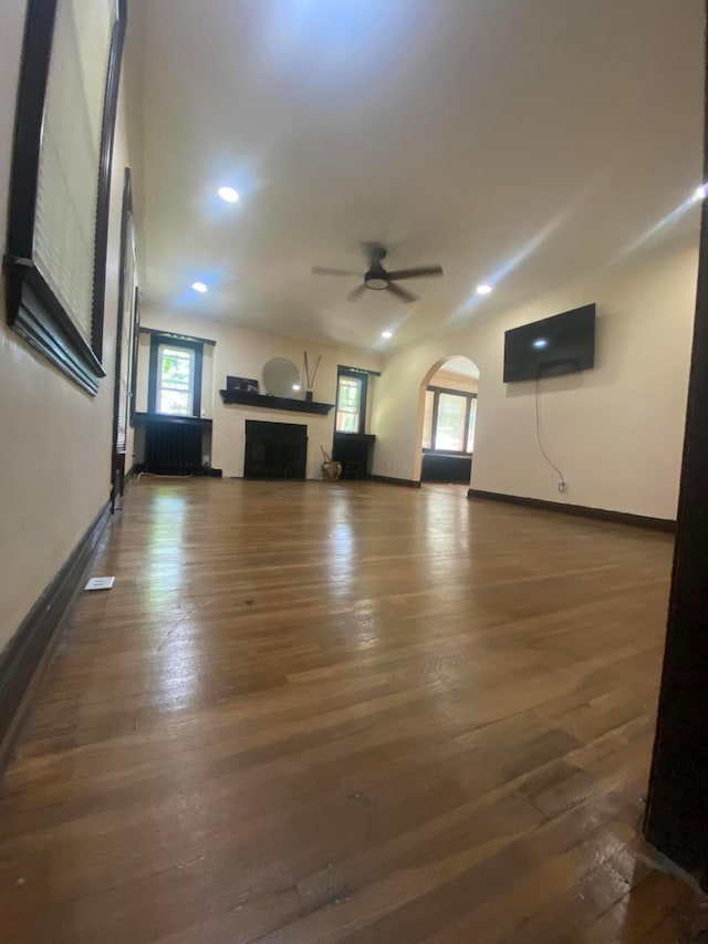 1065 Sunbury Rd, Columbus, OH 43219 - unfurnished living room with a ceiling fan, wood finished floors, a fireplace, recessed lighting, and arched walkways