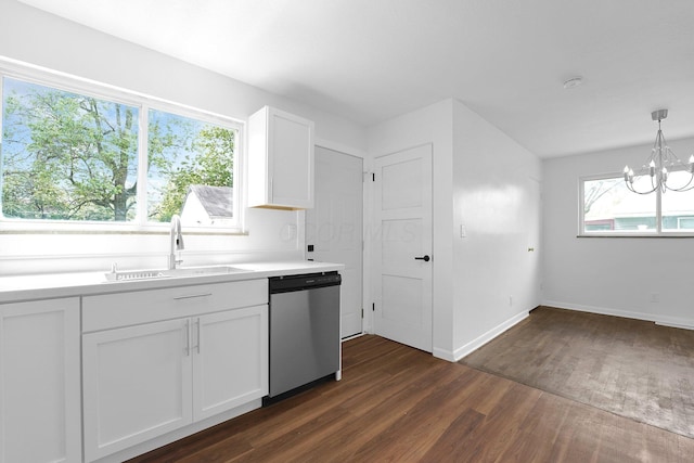 kitchen with stainless steel dishwasher, a sink, dark wood finished floors, a chandelier, and light countertops