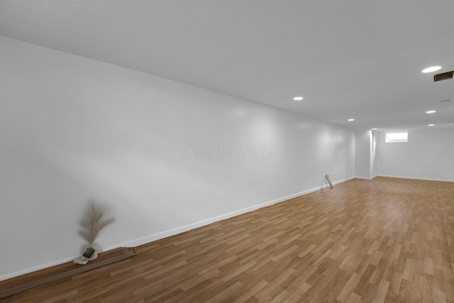 empty room with light wood-style flooring, recessed lighting, and baseboards
