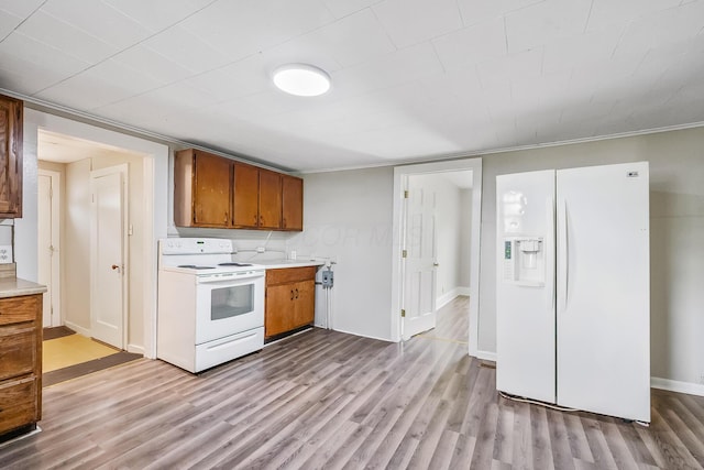349 E Central Ave, Delaware, OH 43015 - kitchen with white appliances, light countertops, light wood-type flooring, and brown cabinetry