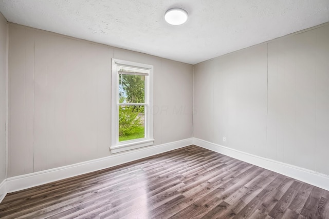 349 E Central Ave, Delaware, OH 43015 - empty room featuring wood finished floors, baseboards, and a textured ceiling