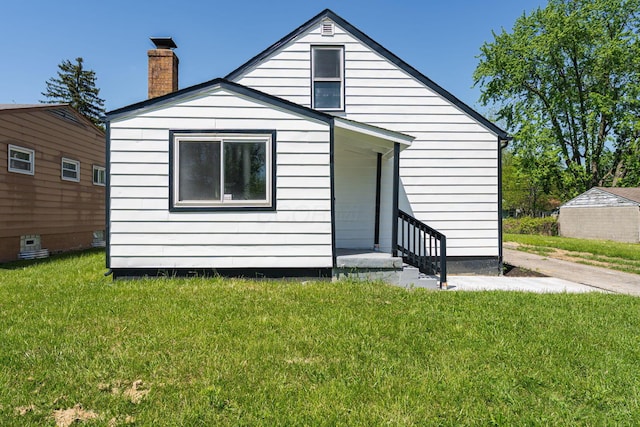 back of property with a yard and a chimney