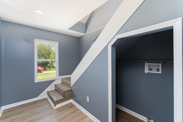 staircase with wood finished floors, baseboards, and recessed lighting
