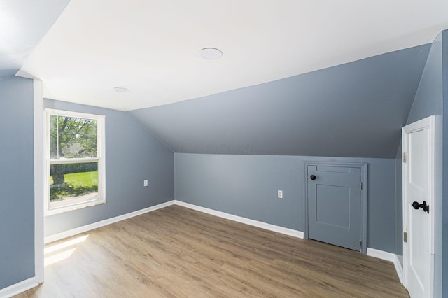 additional living space featuring lofted ceiling, wood finished floors, and baseboards