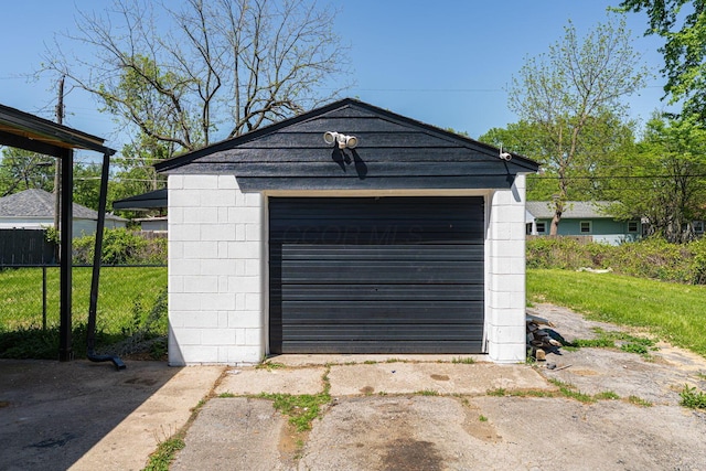 detached garage with fence and driveway