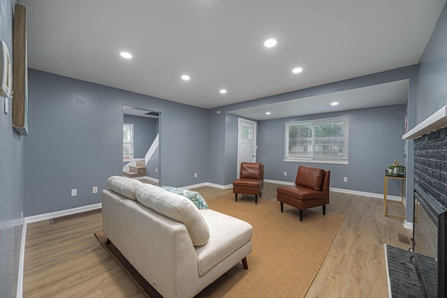1828 Ferris Rd, Columbus, OH 43224 - living room with a fireplace, light wood-style flooring, recessed lighting, and stairs