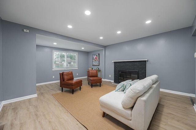1828 Ferris Rd, Columbus, OH 43224 - living room featuring light wood-style floors, a stone fireplace, and recessed lighting