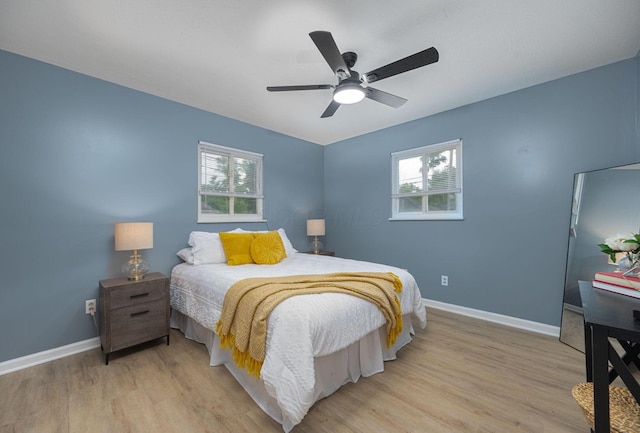 1828 Ferris Rd, Columbus, OH 43224 - bedroom with multiple windows, light wood-type flooring, and a ceiling fan