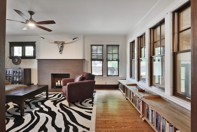 2663 Glen Echo Dr, Columbus, OH 43202 - living area featuring wood finished floors, ceiling fan, a brick fireplace, crown molding, and baseboards
