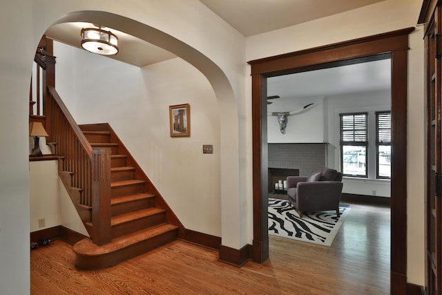 2663 Glen Echo Dr, Columbus, OH 43202 - staircase with wood finished floors, arched walkways, baseboards, and a fireplace