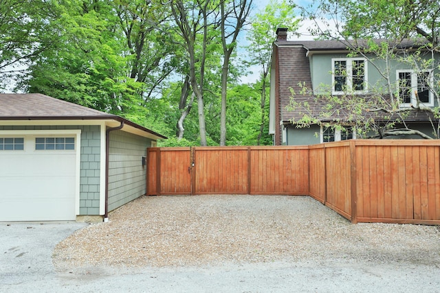 2663 Glen Echo Dr, Columbus, OH 43202 - view of home's exterior with a chimney, a garage, a shingled roof, and fence