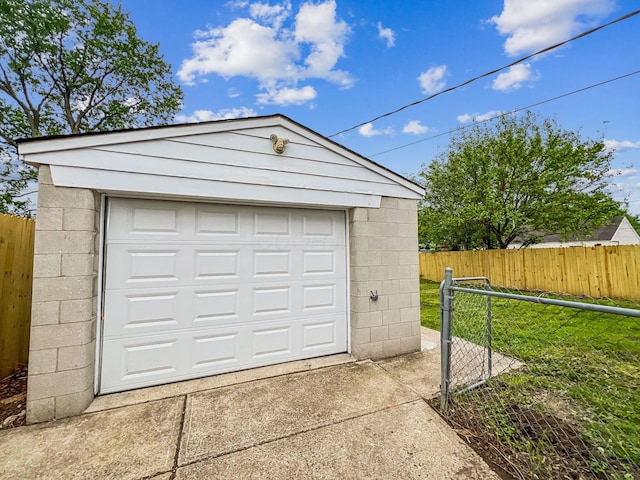 detached garage with fence and concrete driveway