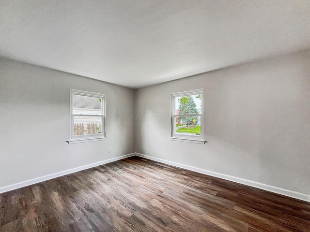 unfurnished room featuring dark wood finished floors and baseboards