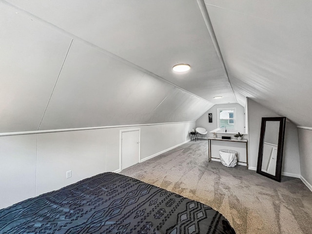 unfurnished bedroom featuring vaulted ceiling, carpet, and baseboards