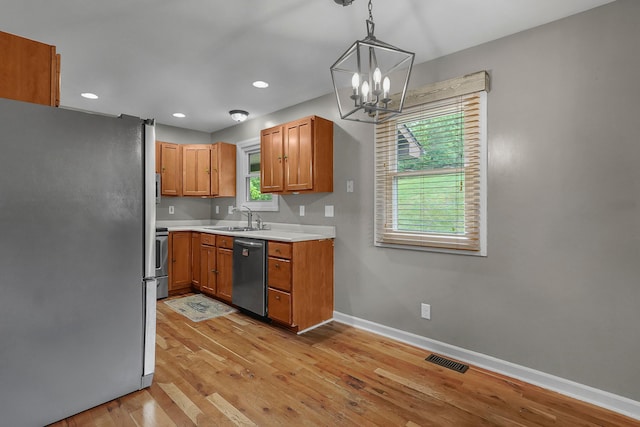 6334 Hansley Rd SE, Sugar Grove, OH 43155 - kitchen with appliances with stainless steel finishes, a chandelier, baseboards, light countertops, and light wood-style floors