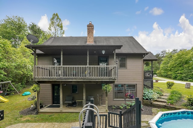 6334 Hansley Rd SE, Sugar Grove, OH 43155 - rear view of property featuring a balcony, a chimney, a lawn, a playground, and a wooden deck