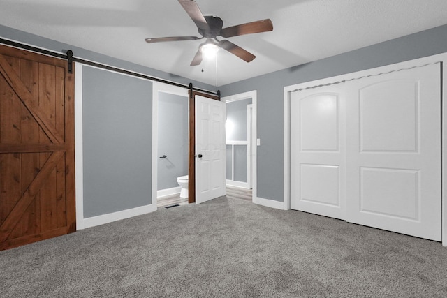 2433 Nedra St, Grove City, OH 43123 - unfurnished bedroom with a barn door, carpet flooring, a ceiling fan, a closet, and ensuite bathroom