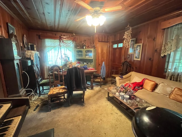 living area featuring a ceiling fan and wood walls