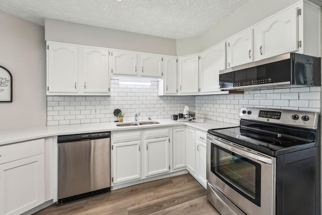 407 Yarmouth Ln, Columbus, OH 43228 - kitchen featuring stainless steel appliances, a sink, white cabinetry, a textured ceiling, and tasteful backsplash