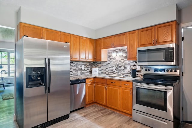 135 N Creekview Ct, Baltimore, OH 43105 - kitchen featuring appliances with stainless steel finishes, a sink, light wood-type flooring, decorative backsplash, and light stone counters